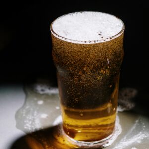 Close-up shot of a refreshing beer with foam overflowing, perfect for Oktoberfest themes.